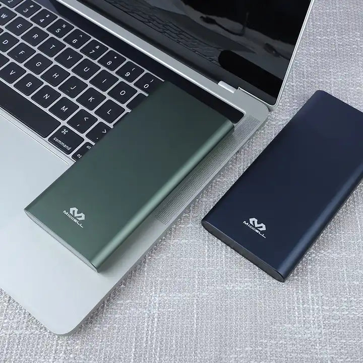 powerbank color verde y azul vq-p120 miccell sobre laptop 